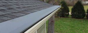 A seamless gutter system on a suburban home's roofline