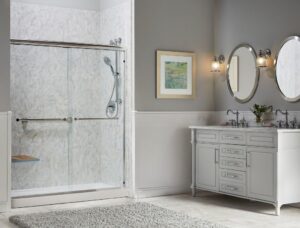 A modern bathroom with a walk-in shower and white fixtures and tile