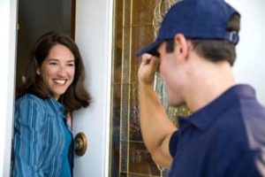 Smiling homeowner answering door after remodeling contractor knocked